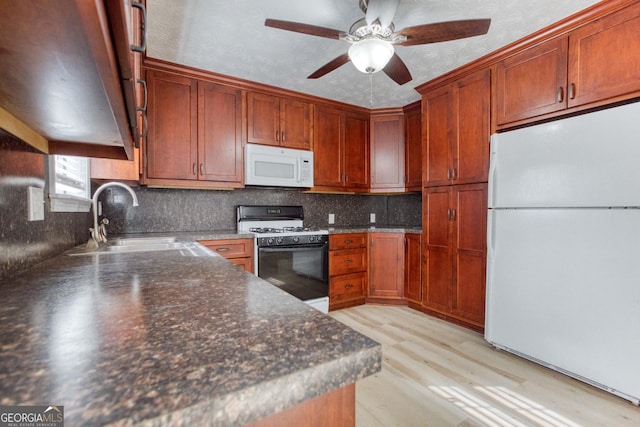 kitchen featuring ceiling fan, sink, backsplash, light hardwood / wood-style floors, and white appliances