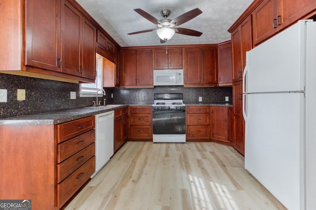 kitchen featuring ceiling fan, sink, light hardwood / wood-style flooring, white appliances, and decorative backsplash