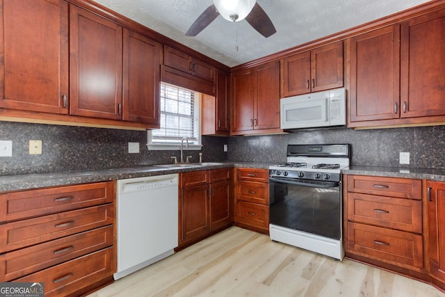 kitchen featuring tasteful backsplash, sink, white appliances, and light wood-type flooring