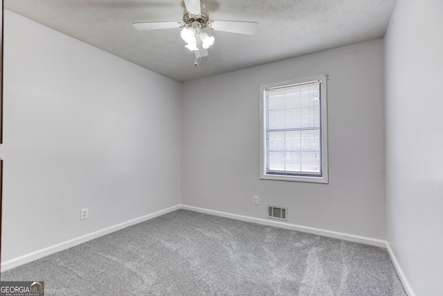 empty room with carpet, ceiling fan, and a textured ceiling