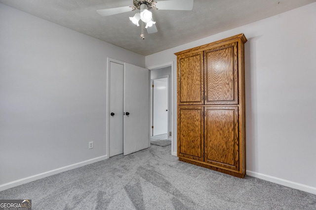 unfurnished bedroom featuring light carpet and ceiling fan