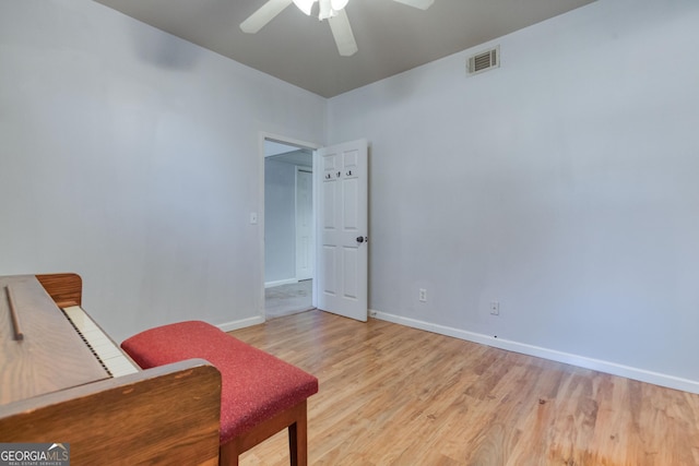 living area with ceiling fan and light hardwood / wood-style flooring