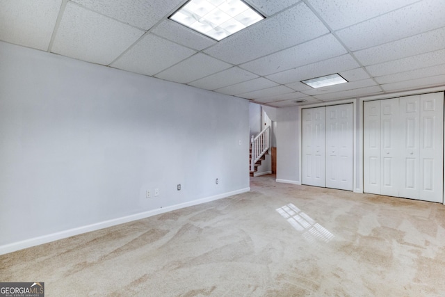 basement with a drop ceiling and carpet