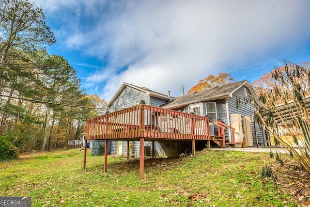 back of house featuring a wooden deck and a yard