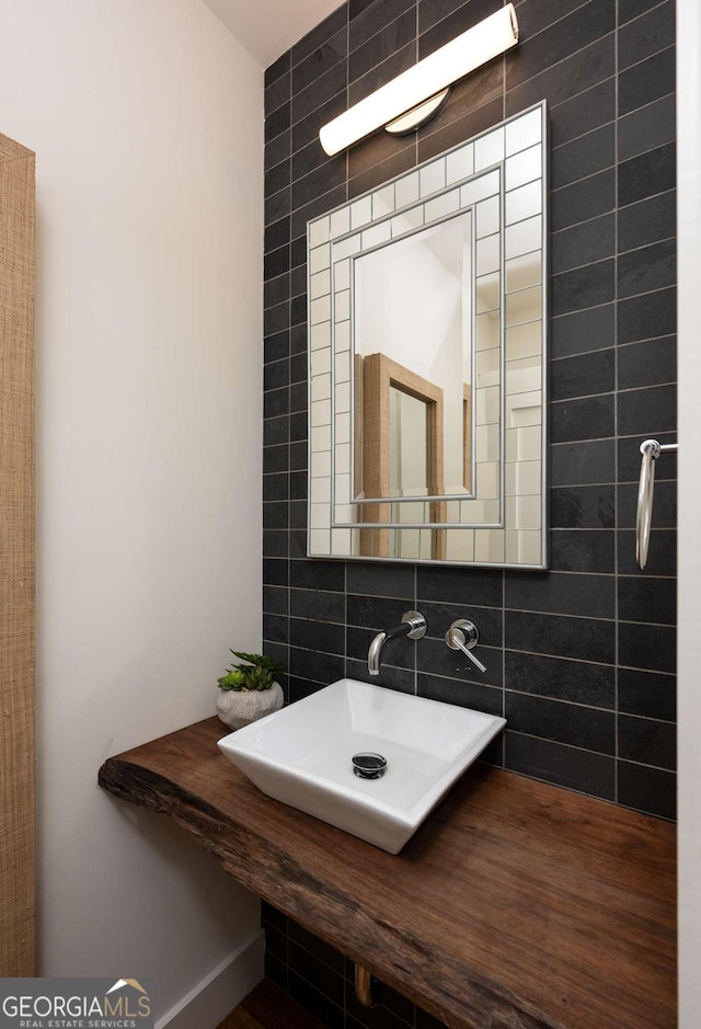 bathroom featuring backsplash, sink, hardwood / wood-style floors, and tile walls