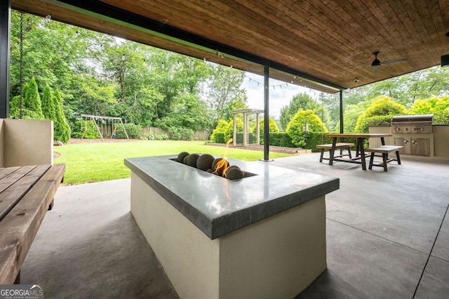 view of patio with a playground, grilling area, and exterior kitchen