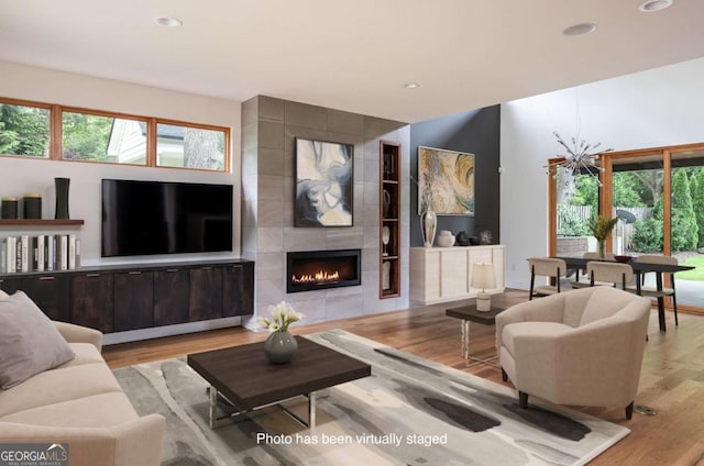 living room with a tile fireplace and light wood-type flooring