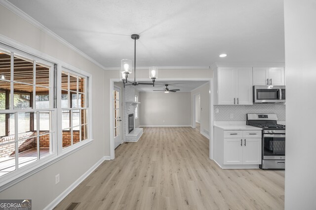 kitchen with white cabinets, stainless steel appliances, and light hardwood / wood-style flooring