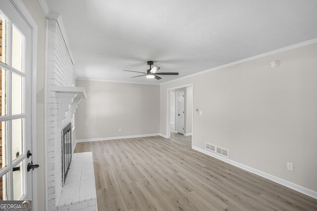 unfurnished living room featuring ceiling fan, crown molding, light wood-type flooring, and a fireplace