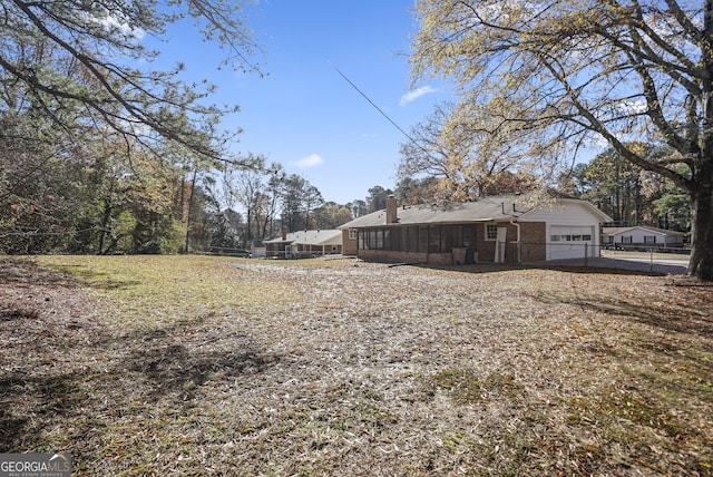 view of yard featuring a sunroom and a garage