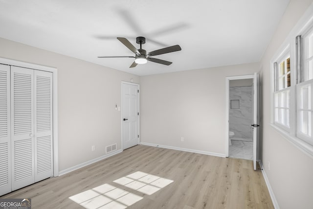 unfurnished bedroom featuring ceiling fan, a closet, ensuite bath, and light hardwood / wood-style flooring