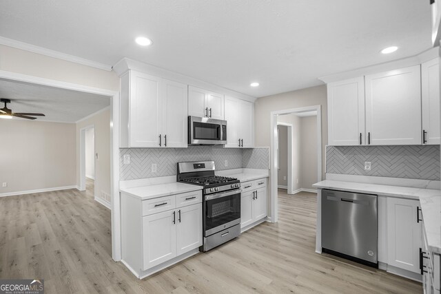 kitchen featuring stainless steel appliances, white cabinetry, and light hardwood / wood-style floors