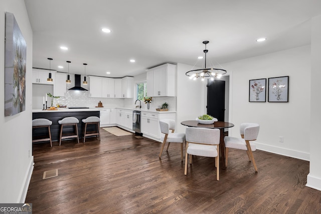 dining space featuring sink, dark hardwood / wood-style floors, and an inviting chandelier