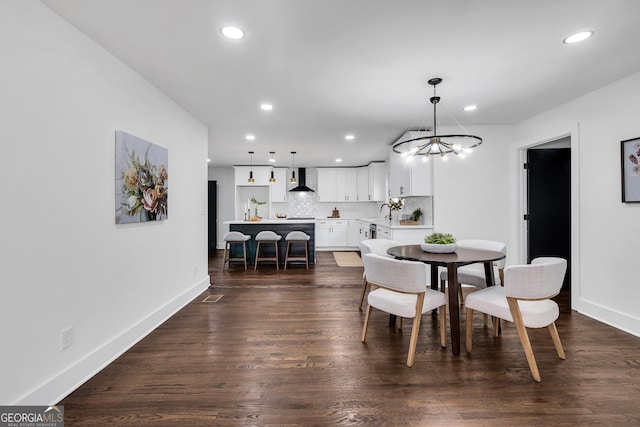 dining room featuring sink, dark hardwood / wood-style flooring, and a notable chandelier