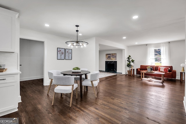 dining space with a chandelier and dark hardwood / wood-style flooring