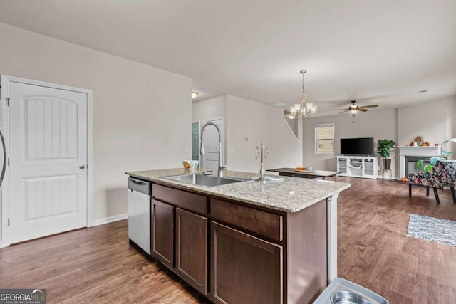 kitchen featuring ceiling fan with notable chandelier, dark wood-type flooring, sink, a center island with sink, and dishwasher