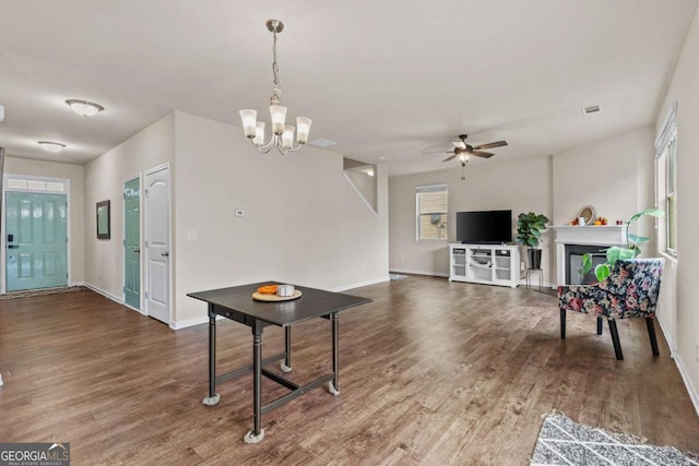 living room with ceiling fan with notable chandelier and hardwood / wood-style flooring