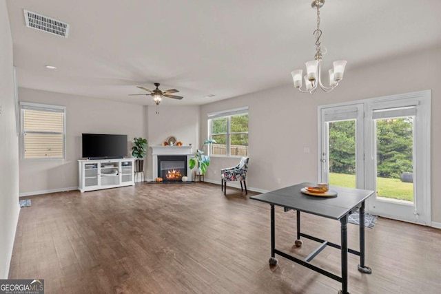 living room featuring hardwood / wood-style floors, ceiling fan with notable chandelier, and a healthy amount of sunlight