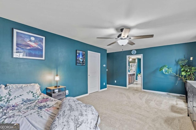 carpeted bedroom with ensuite bath and ceiling fan