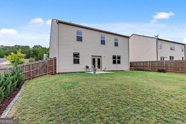 rear view of house featuring a lawn and a patio