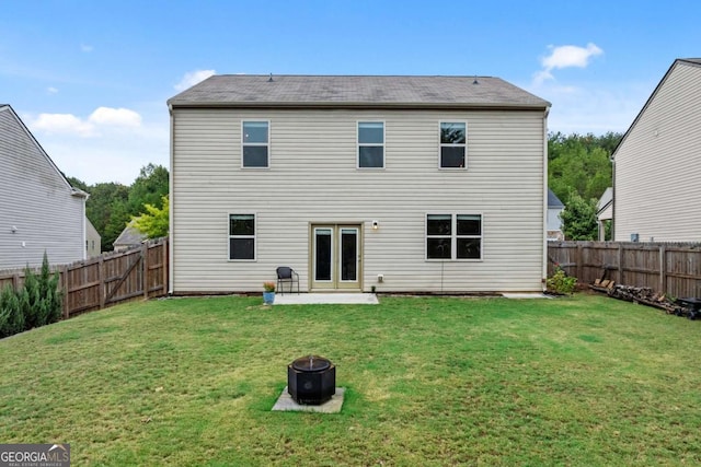 back of house featuring a lawn, a patio area, and french doors