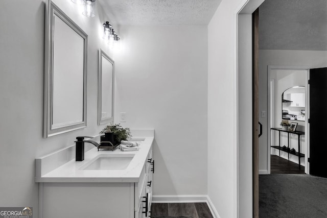 bathroom with vanity, wood-type flooring, and a textured ceiling