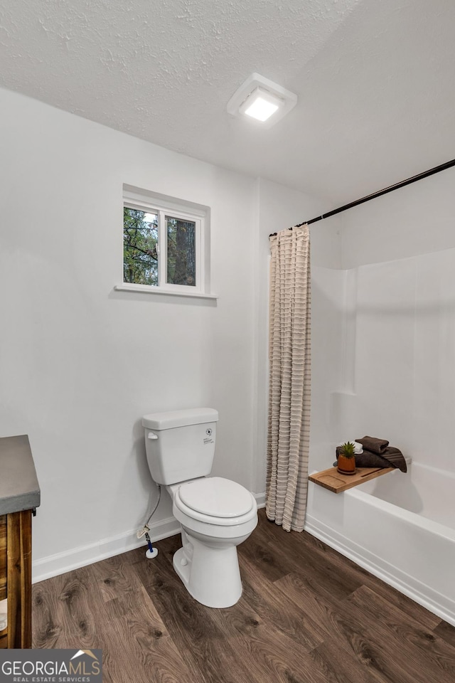 full bathroom featuring toilet, shower / bath combination with curtain, a textured ceiling, and hardwood / wood-style flooring