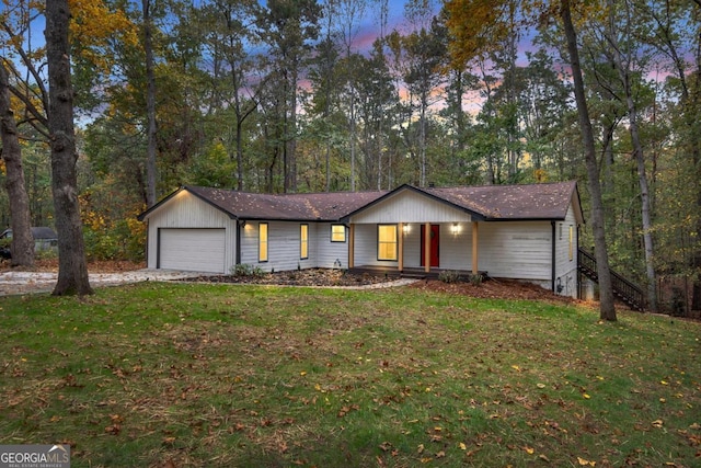 ranch-style home with a garage and a yard