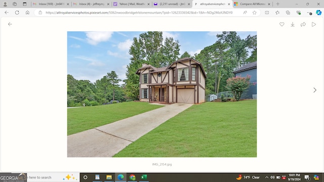 view of front of home with a garage and a front lawn