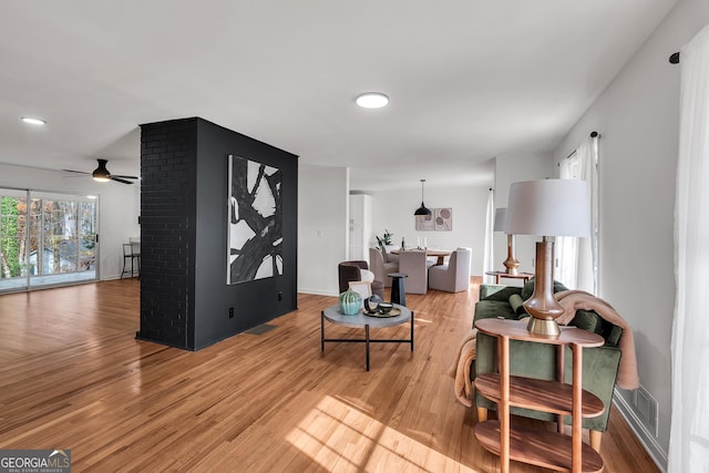 living room featuring ceiling fan and light wood-type flooring