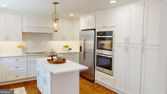 kitchen with backsplash, stainless steel appliances, white cabinetry, and hanging light fixtures