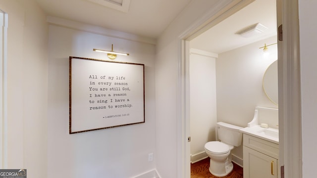 bathroom featuring vanity, wood-type flooring, and toilet