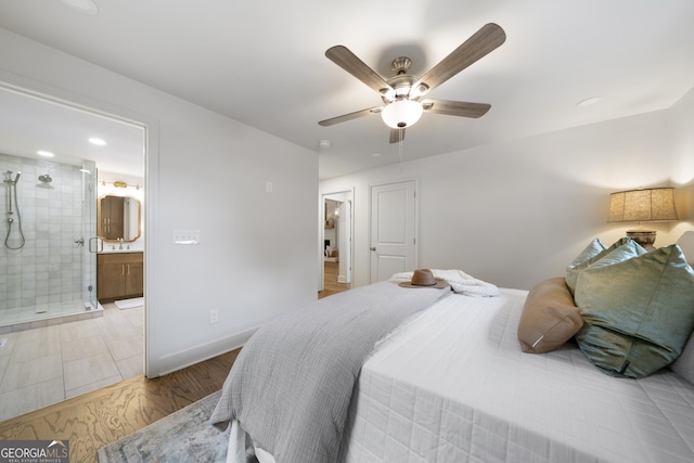 bedroom with ensuite bathroom, ceiling fan, and light hardwood / wood-style flooring