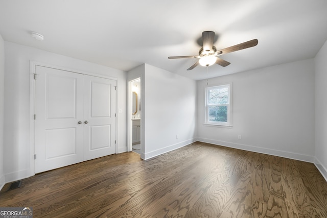 unfurnished bedroom featuring connected bathroom, ceiling fan, a closet, and dark hardwood / wood-style floors