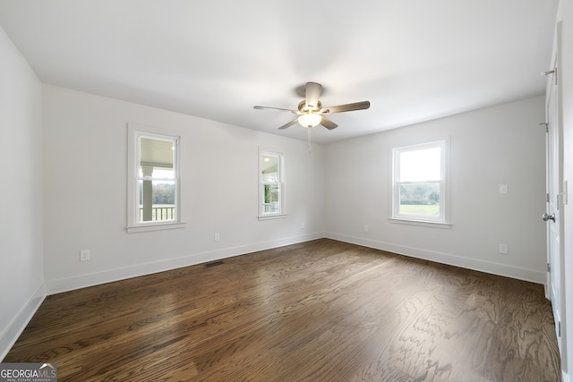 unfurnished room with ceiling fan, a healthy amount of sunlight, and dark wood-type flooring