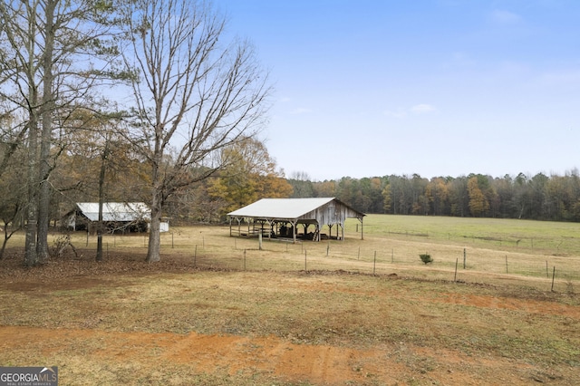 view of yard with a rural view and an outdoor structure