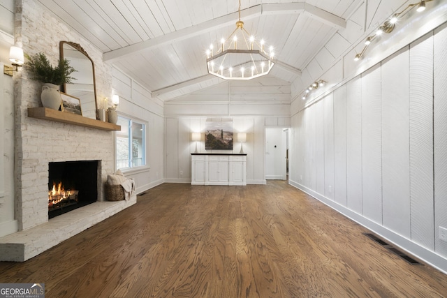 unfurnished living room featuring wood ceiling, wood-type flooring, lofted ceiling with beams, an inviting chandelier, and a fireplace