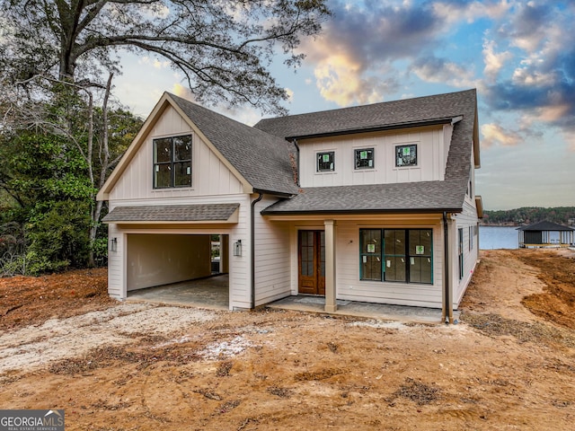 view of front of home with a carport, a porch, and a garage