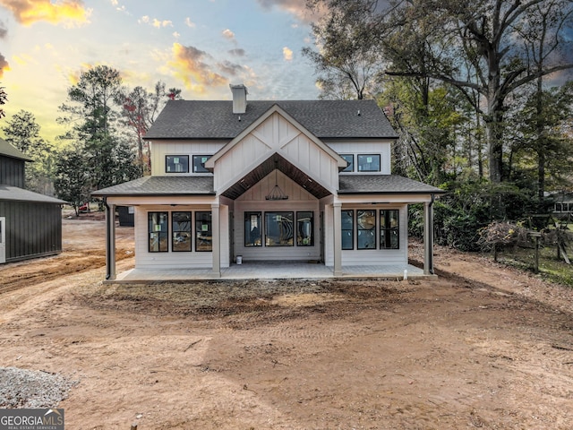 back house at dusk featuring a patio area