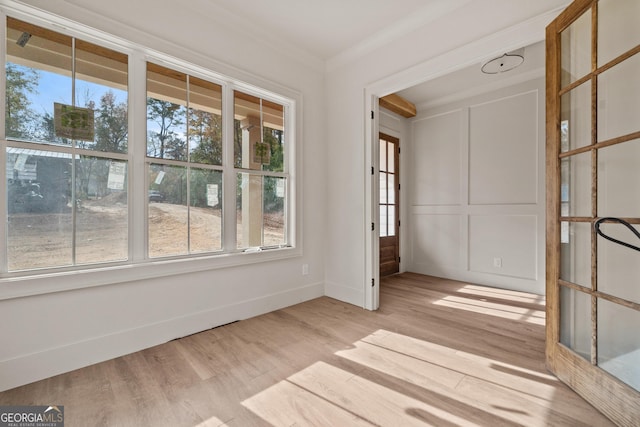 empty room featuring light hardwood / wood-style floors and ornamental molding