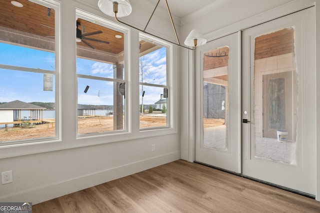 unfurnished sunroom featuring ceiling fan