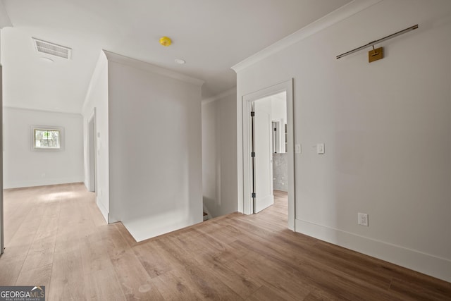 hall featuring light wood-type flooring and crown molding