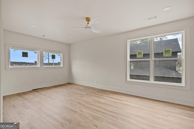 spare room with ceiling fan, plenty of natural light, and light hardwood / wood-style flooring