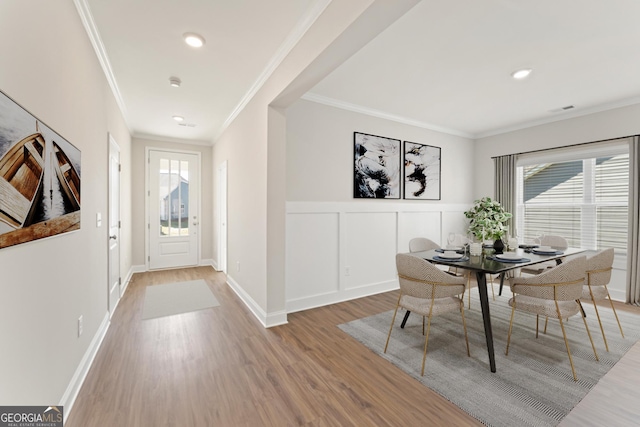 dining space with wood-type flooring and crown molding