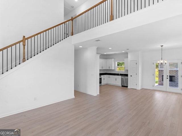 1215 White Oak Way, Griffin, GA 30224 - unfurnished living room with a chandelier, light wood-type flooring, recessed lighting, stairway, and baseboards