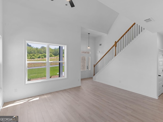 1215 White Oak Way, Griffin, GA 30224 - unfurnished living room with a towering ceiling, a ceiling fan, wood finished floors, baseboards, and stairs