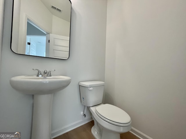 bathroom featuring hardwood / wood-style flooring and toilet