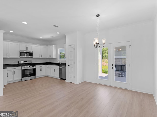 1215 White Oak Way, Griffin, GA 30224 - kitchen featuring appliances with stainless steel finishes, crown molding, dark countertops, white cabinets, and light wood finished floors