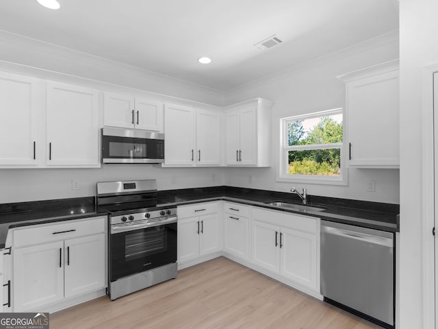1215 White Oak Way, Griffin, GA 30224 - kitchen featuring appliances with stainless steel finishes, a sink, white cabinetry, light wood-style floors, and ornamental molding