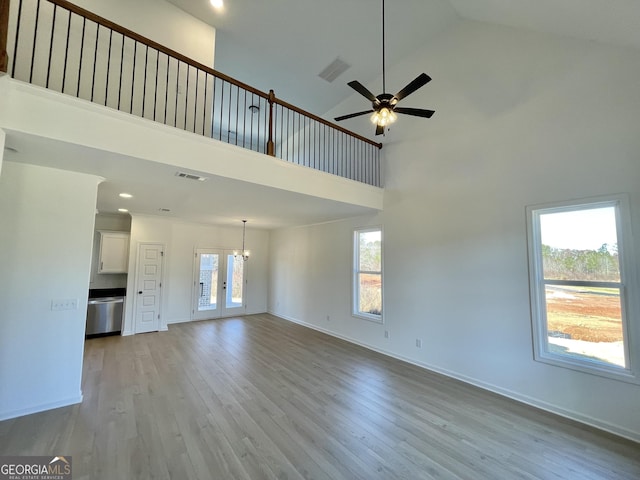 unfurnished living room with light hardwood / wood-style flooring, high vaulted ceiling, and a wealth of natural light